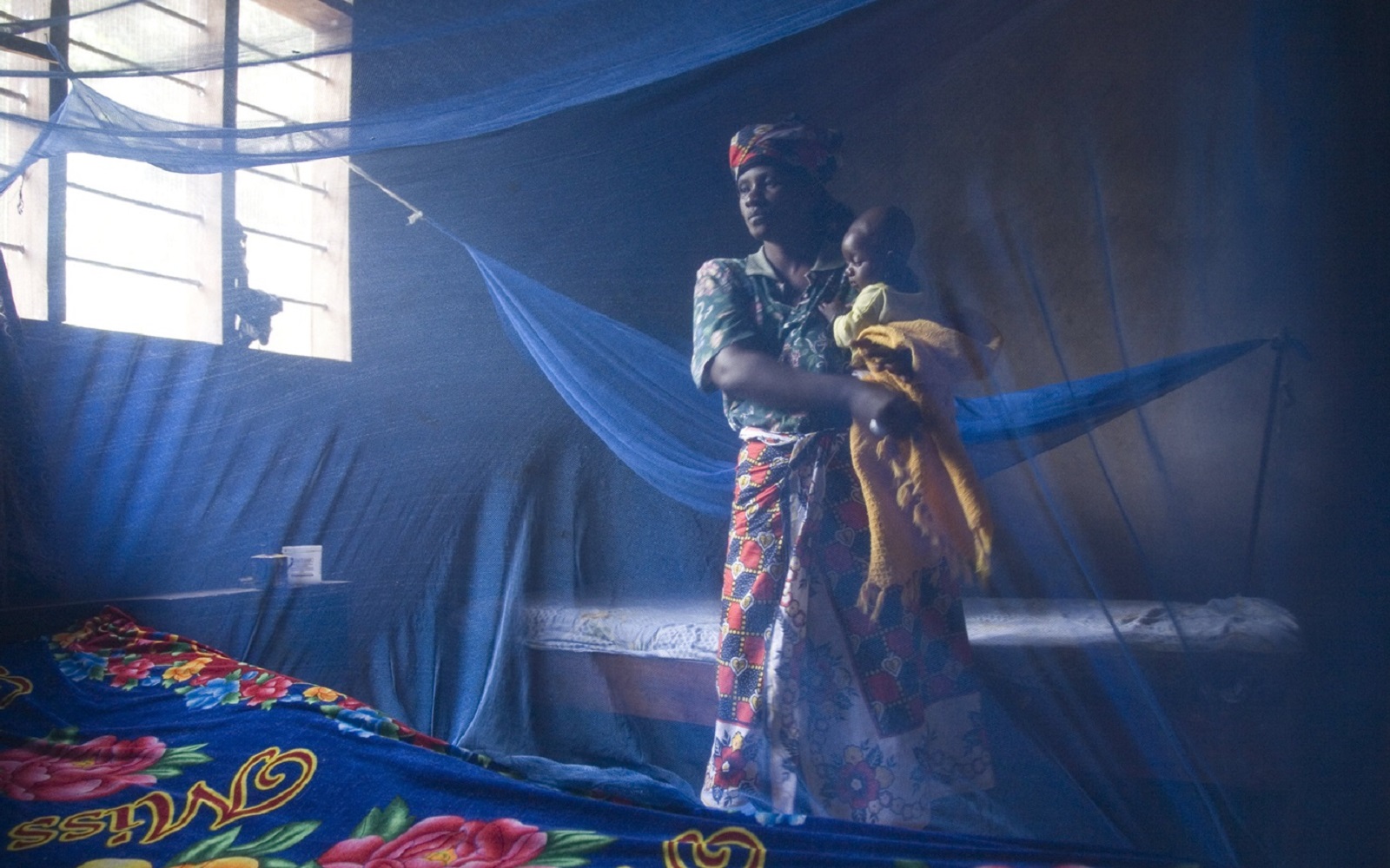 A woman and child with bed nets in their home in Lupiro village, Tanzania.
